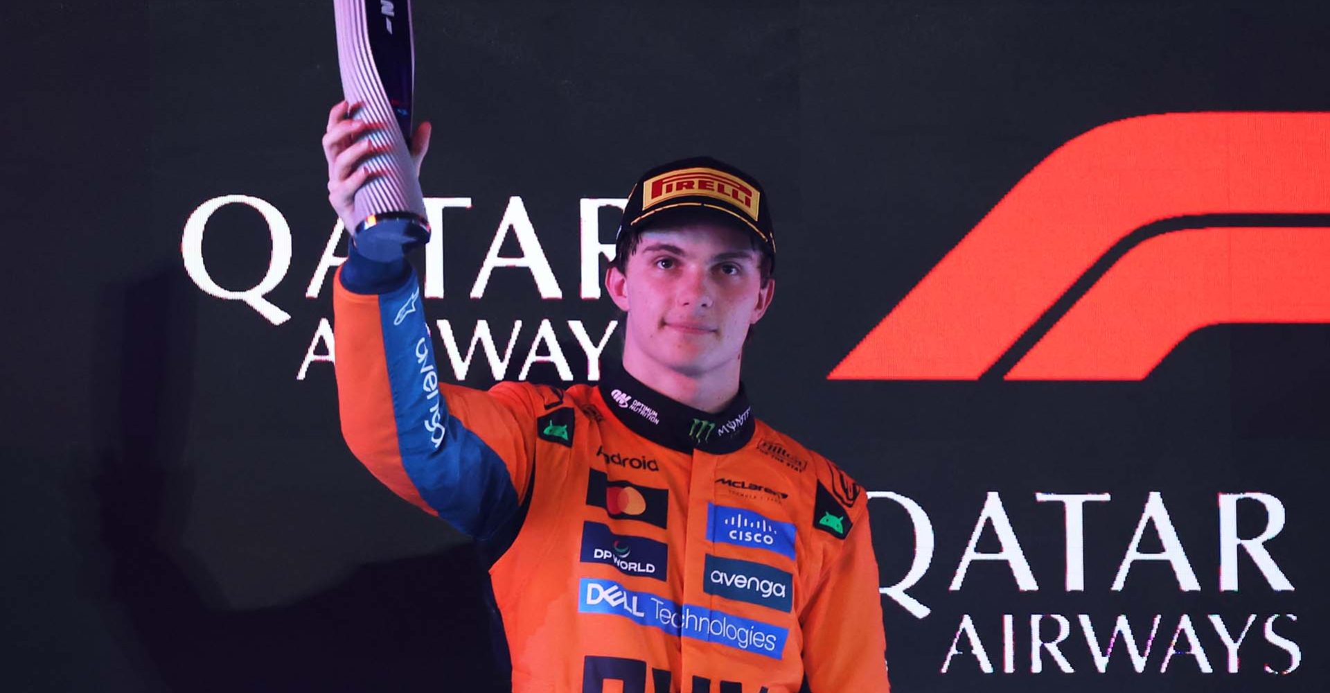 LUSAIL CITY, QATAR - NOVEMBER 30: Second placed Oscar Piastri of Australia and McLaren lifts his trophy on the podium during the F1 Grand Prix of Qatar at Lusail International Circuit on November 30, 2025 in Lusail City, Qatar. (Photo by Dom Gibbons/LAT Images)
