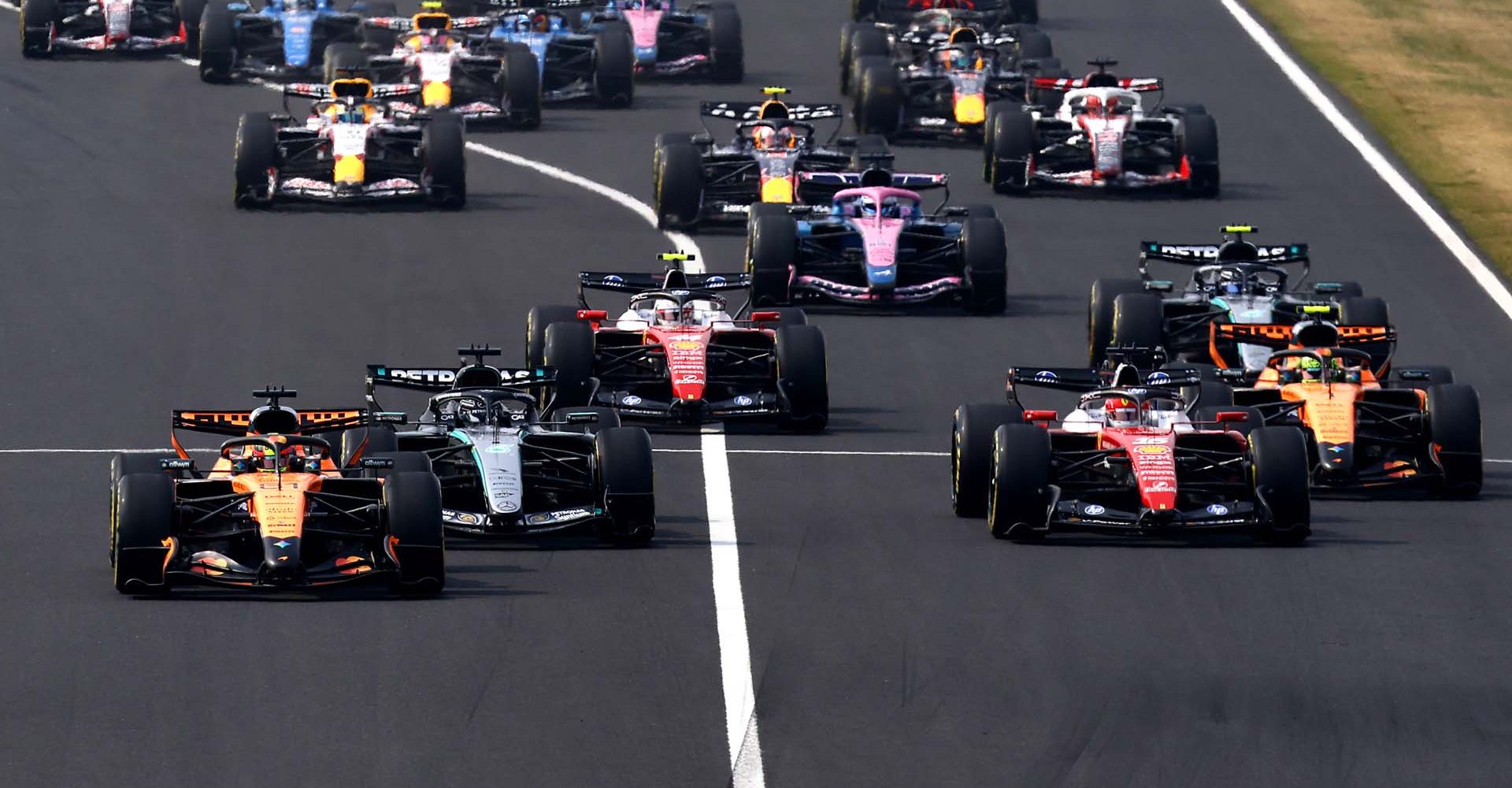 SUZUKA, JAPAN - MARCH 29: Oscar Piastri of Australia driving the (81) McLaren MCL40 Mercedes leads George Russell of Great Britain driving the (63) Mercedes AMG Petronas F1 Team W17 Charles Leclerc of Monaco driving the (16) Scuderia Ferrari SF-26 and the rest of the field at the start during the F1 Grand Prix of Japan at Suzuka Circuit on March 29, 2026 in Suzuka, Japan. (Photo by Mark Thompson/Getty Images)