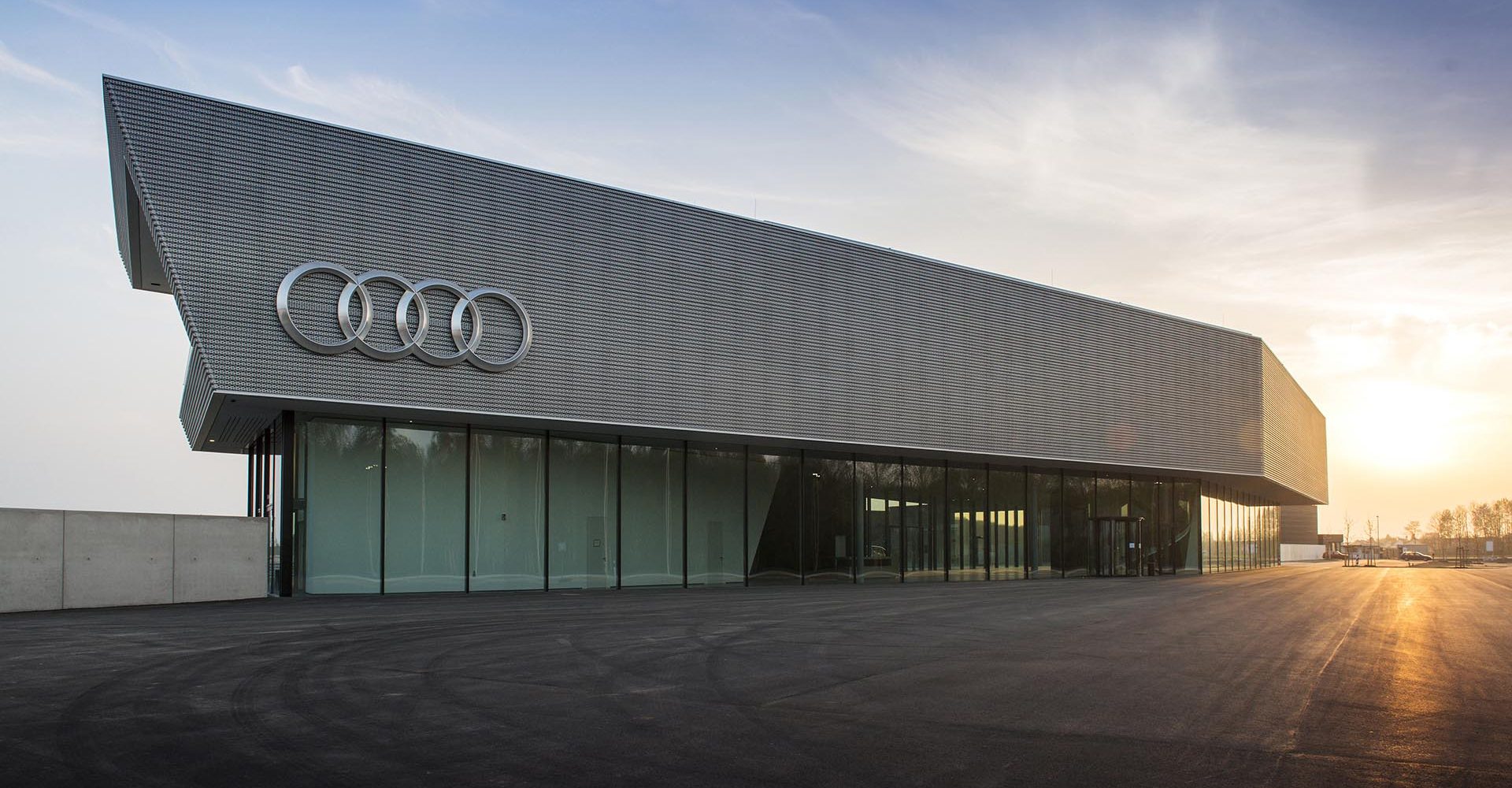 Audi Neuburg is an integral component of the global investment strategy of AUDI AG. The 47-hectare site lies west of Ingolstadt, just 18 km (11.2 mi) from Audi headquarters.
The grounds are the home of the new Audi driving experience center. Beginning in May 2014, ambitious drivers can experience the Audi brand during driver and safety training courses both on-road and off-road. 
The Motorsport Competence Center, the new headquarters of Audi Sport, is also being constructed here. From fall 2014, all motorsport racing cars will be developed, designed and built here.

Here:
The central customer building at the Audi Neuburg site offers presentation spaces
on multiple floors as well as a restaurant. From the terrace, customers enjoy
a panoramic view of the entire site and the cars on the tracks.