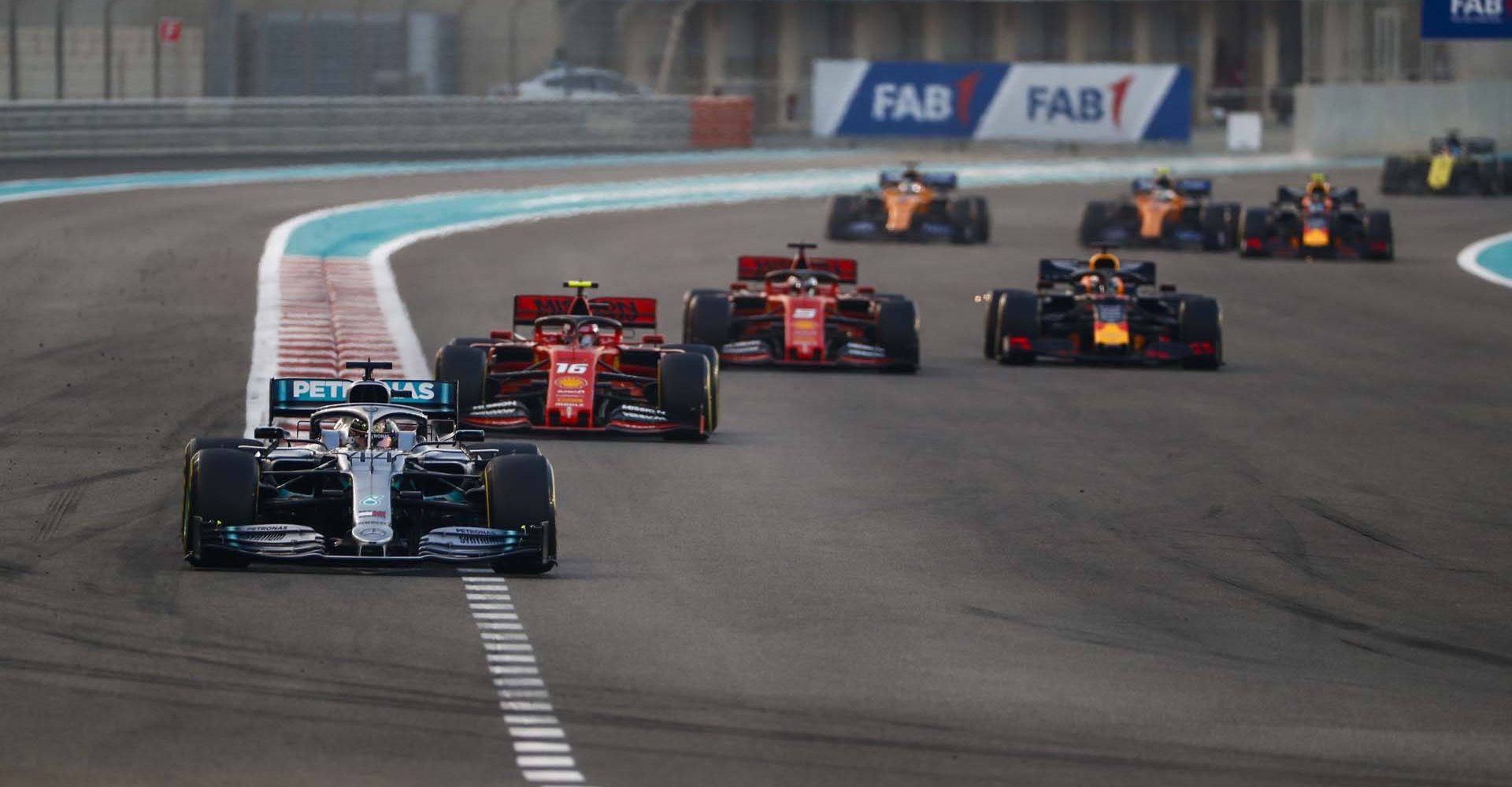 YAS MARINA CIRCUIT, UNITED ARAB EMIRATES - DECEMBER 01: Lewis Hamilton, Mercedes AMG F1 W10, leads Charles Leclerc, Ferrari SF90, Sebastian Vettel, Ferrari SF90, Max Verstappen, Red Bull Racing RB15, and the rest of the field on the opening lap during the Abu Dhabi GP at Yas Marina Circuit on December 01, 2019 in Yas Marina Circuit, United Arab Emirates. (Photo by Sam Bloxham / LAT Images)