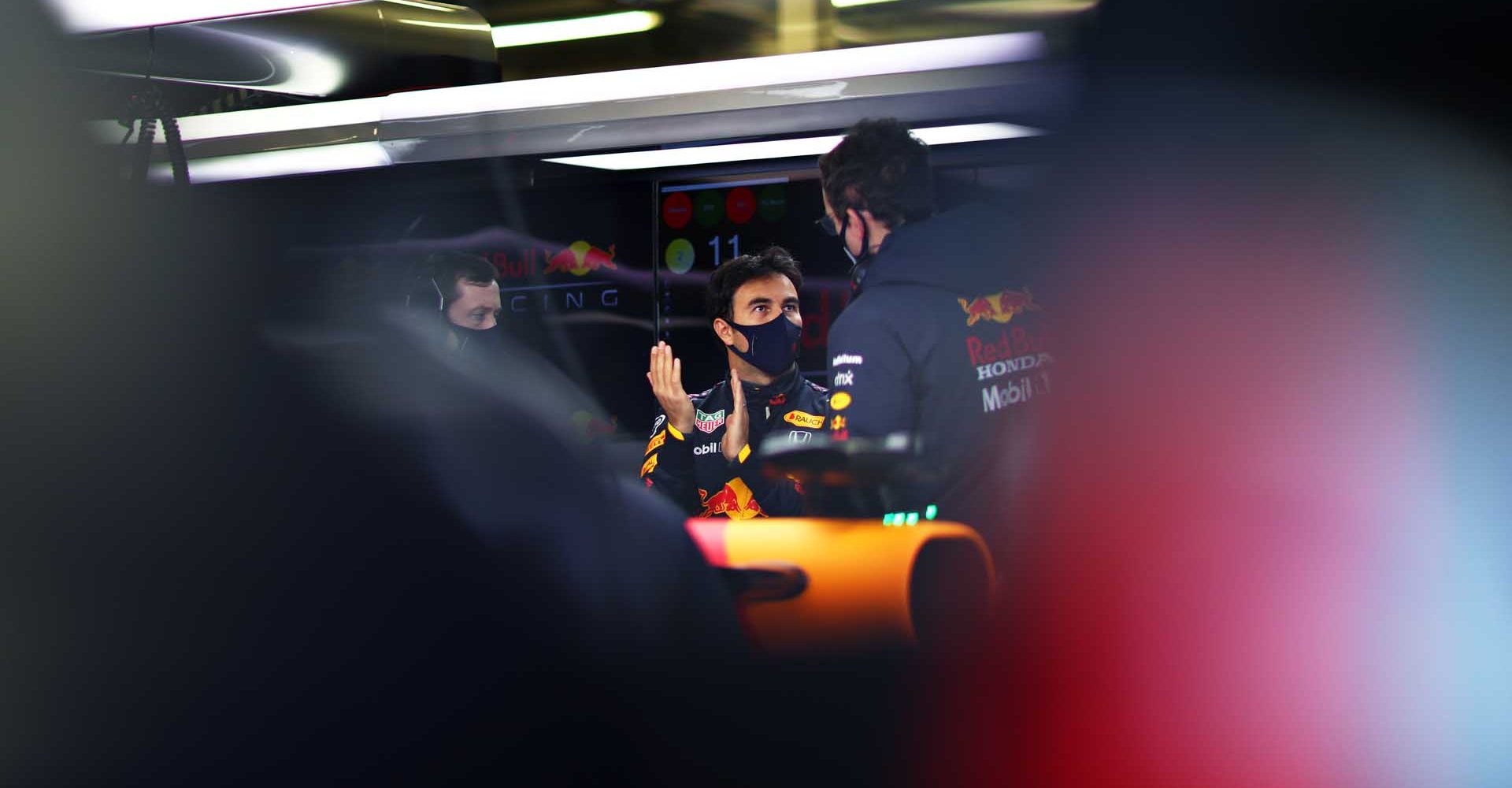 NORTHAMPTON, ENGLAND - FEBRUARY 24: Sergio Perez of Mexico and Red Bull Racing talks with his engineer in the garage during the Red Bull Racing Filming Day at Silverstone on February 24, 2021 in Northampton, England. (Photo by Dan Istitene/Getty Images for Red Bull Racing)