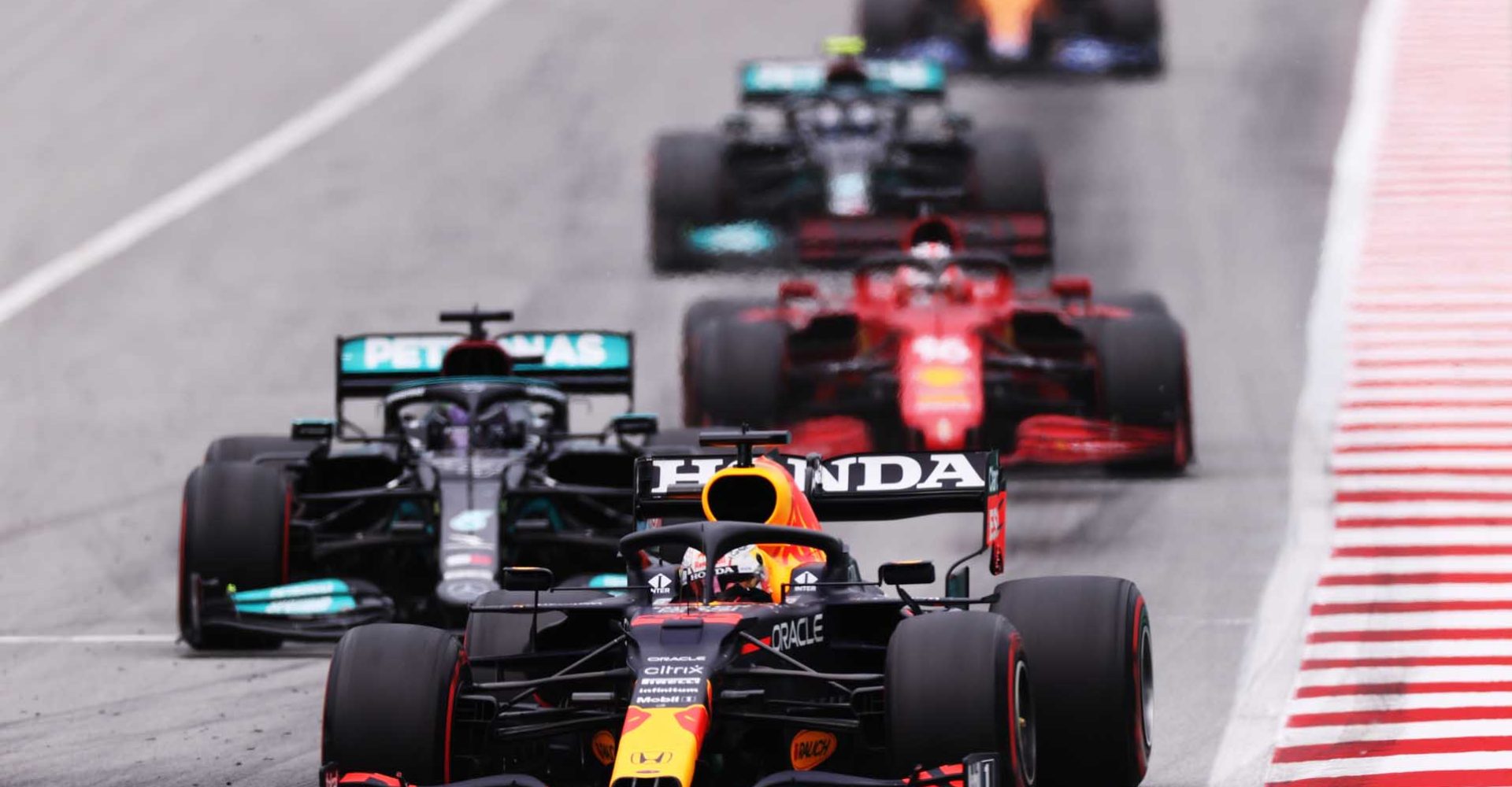 BARCELONA, SPAIN - MAY 09: Max Verstappen of the Netherlands driving the (33) Red Bull Racing RB16B Honda leads Lewis Hamilton of Great Britain driving the (44) Mercedes AMG Petronas F1 Team Mercedes W12 and the rest of the field during the F1 Grand Prix of Spain at Circuit de Barcelona-Catalunya on May 09, 2021 in Barcelona, Spain. (Photo by Lars Baron/Getty Images)