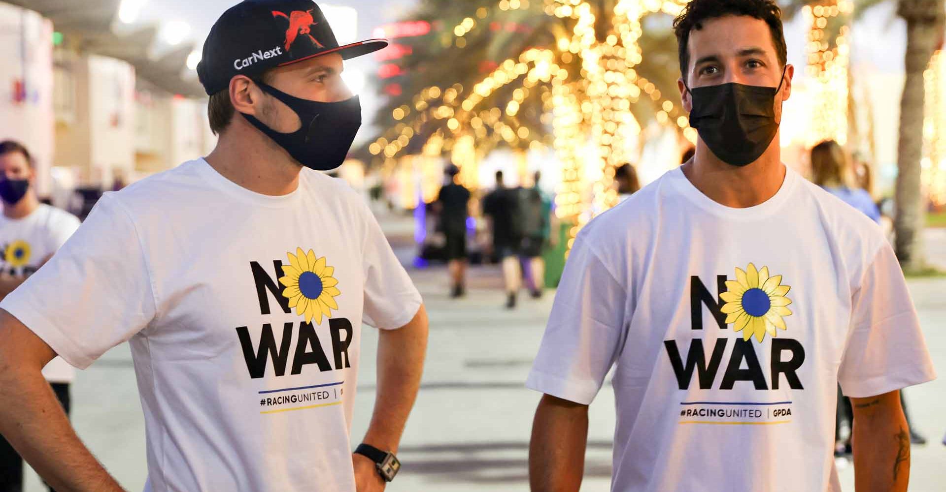 BAHRAIN, BAHRAIN - MARCH 09: Max Verstappen of the Netherlands and Oracle Red Bull Racing and Daniel Ricciardo of Australia and McLaren talk while wearing t-shirts promoting peace and sympathy with Ukraine prior to F1 Testing at Bahrain International Circuit on March 09, 2022 in Bahrain, Bahrain. (Photo by Mark Thompson/Getty Images)