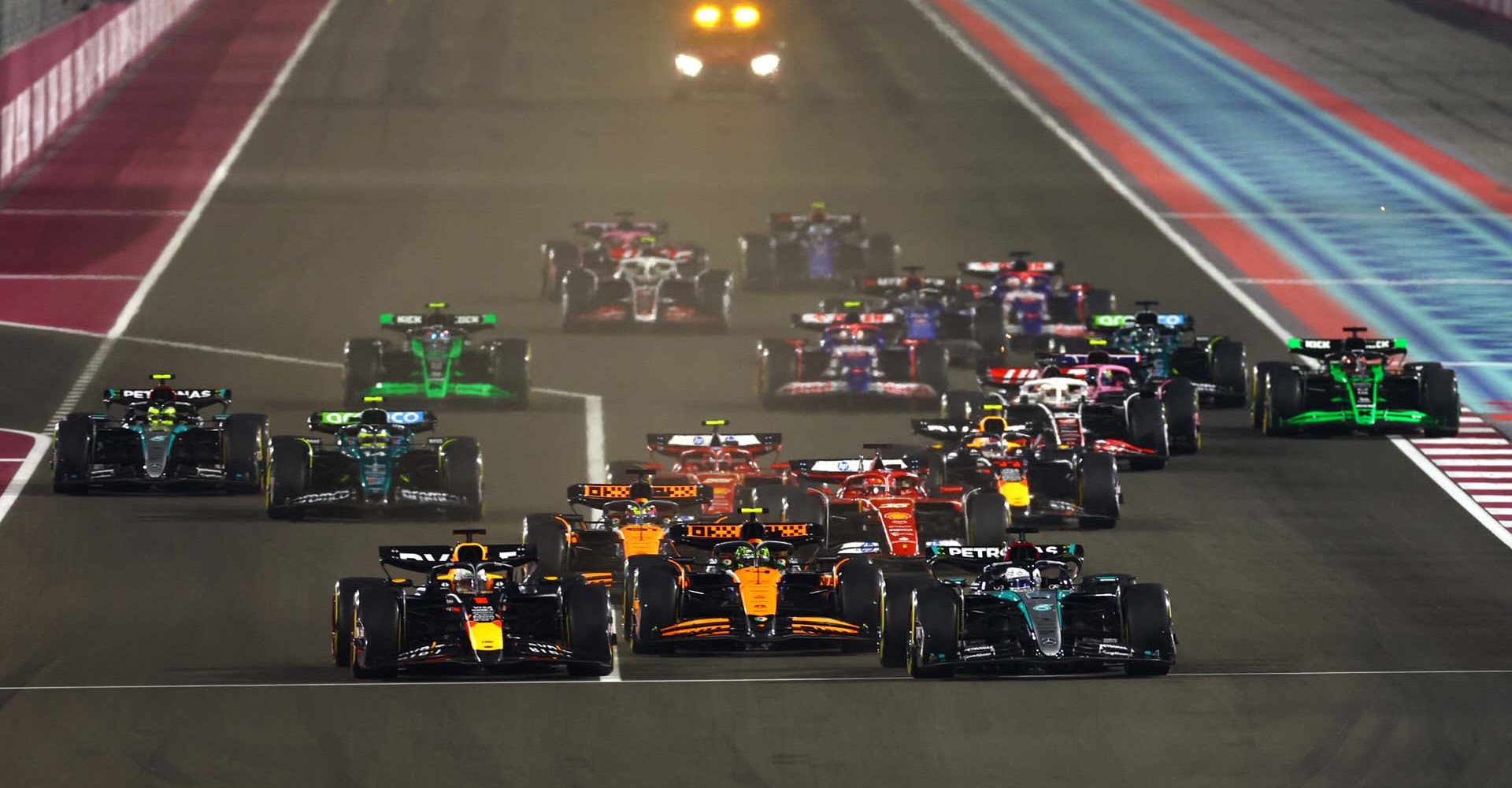 LUSAIL CITY, QATAR - DECEMBER 01: George Russell of Great Britain driving the (63) Mercedes AMG Petronas F1 Team W15 and Max Verstappen of the Netherlands driving the (1) Oracle Red Bull Racing RB20 lead the field into turn 1 at the start during the F1 Grand Prix of Qatar at Lusail International Circuit on December 01, 2024 in Lusail City, Qatar. (Photo by Mark Thompson/Getty Images) // Getty Images / Red Bull Content Pool // SI202412010190 // Usage for editorial use only //